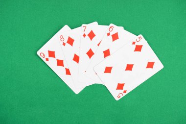 top view of green poker table and unfolded playing cards with diamonds suit