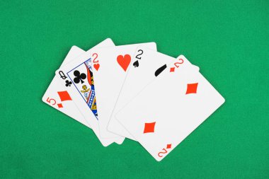 top view of green poker table with unfolded playing cards combination with different suits clipart