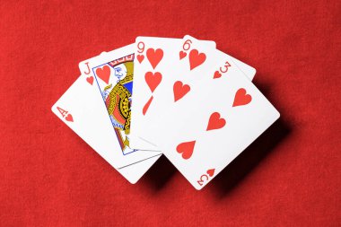 Kırmızı poker masası ve gelişeceğini iskambil kalpler takım elbise ile üstten görünüm