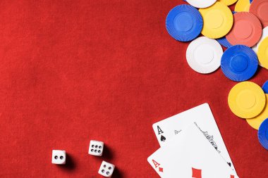 Kırmızı poker masası ve çok renkli cips, dices ve kartları üstten görünüm 