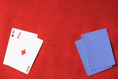 güvertede kırmızı poker masası ve oyun kağıdı elmas takım elbise ile üstten görünüm