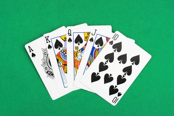 Top view of green poker table and unfolded playing cards with spades suit Stock Picture