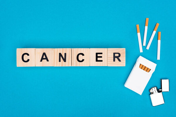 Плоская укладка сигарет и деревянных кубиков с текстом, изолированным на голубом, бросить курить концепции
