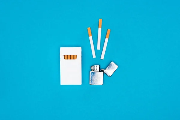 Κάτοψη Του Πακέτο Λευκό Τσιγάρο Και Αναπτήρα Που Απομονώνονται Μπλε — Φωτογραφία Αρχείου