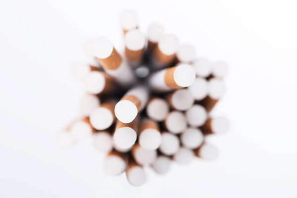 Top view of cigarettes with selective focus isolated on white