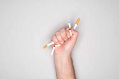 Adamın elinde sigara kırma kısmi görünümü gri, izole durdurmak sigara kavramı