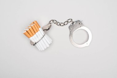 Kelepçe ve gri, nikotin bağımlılığı kavramı izole sigara stüdyo çekim