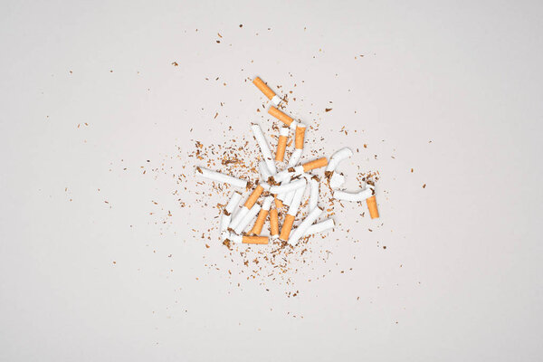 Top view of broken cigarettes isolated on grey, stop smoking concept