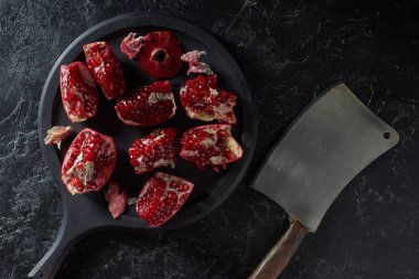 Siyah yüzey üzerinde taze Garnet ve metal satır üstten görünüm