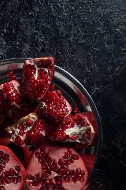 Metal kabın içinde kesilmiş nar üstten görünüm