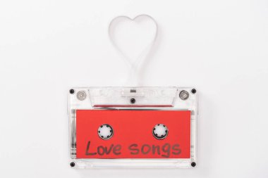 top view of audio cassette with 'love songs' lettering and heart symbol isolated on white, st valentines day concept clipart