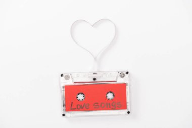 top view of audio cassette with 'love songs' lettering and heart symbol isolated on white, st valentines day concept clipart