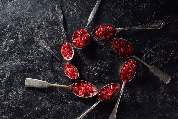 Flat lay with pomegranate seeds in spoons