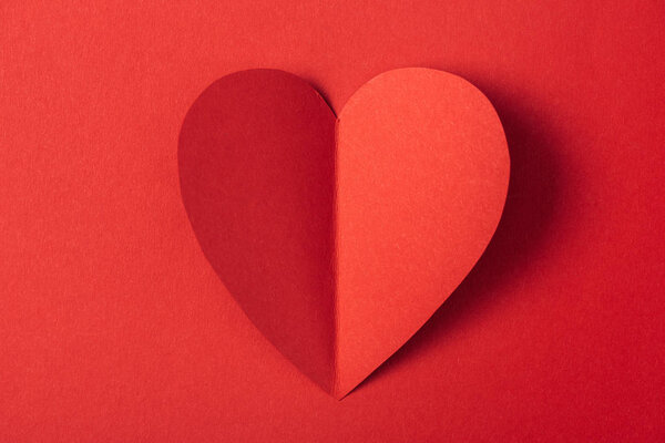 top view of heart shaped paper card isolated on red with copy space, st valentines day concept