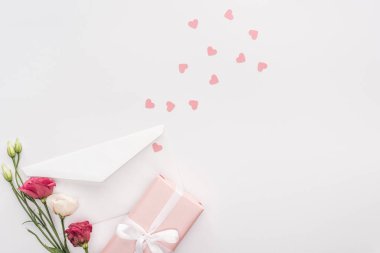 kalplerin üzerine beyaz izole hediye kutusu, çiçekler, zarf ve kağıt üstten görünüm