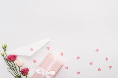 kalplerin üzerine beyaz izole hediye kutusu, çiçekler, zarf ve kağıt üstten görünüm