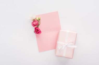 boş pembe kartı, hediye kutusu ve üzerinde beyaz izole çiçek üstten görünüm