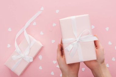 Kırpılan görünümünü pink izole hediye kutusu tutan kadın
