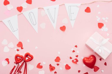 Sevgililer süslemeleri ve kağıt garland pink, st Sevgililer günü kavramı izole 'aşk' yazı ile üstten görünüm