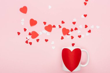 Kağıt kalpleri ve kupa pink, st Sevgililer günü kavramı izole kalp şeklinde etiketi ile üstten görünüm