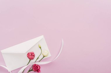 çiçek ve pembe kopya alanı ile izole zarf üstten görünüm