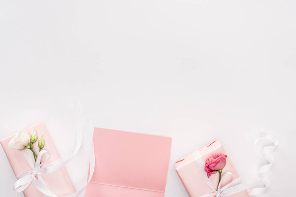 top view of gift boxes, blank card and flowers isolated on white