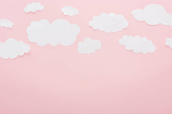 top view of white paper clouds isolated on pink with copy space
