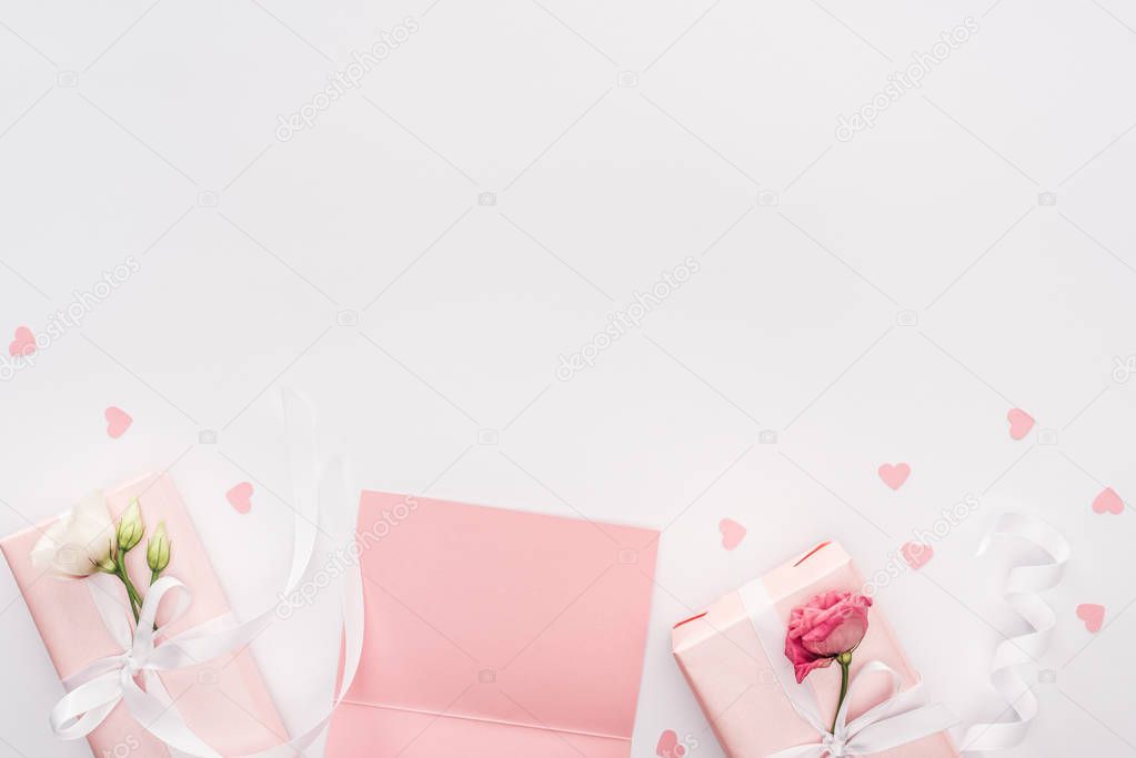 top view of gift boxes, blank card and paper hearts isolated on white with copy space