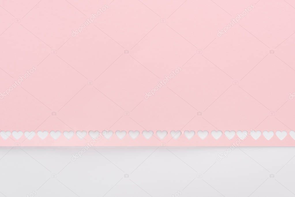 background of cut out hearts in row on pink paper isolated on white
