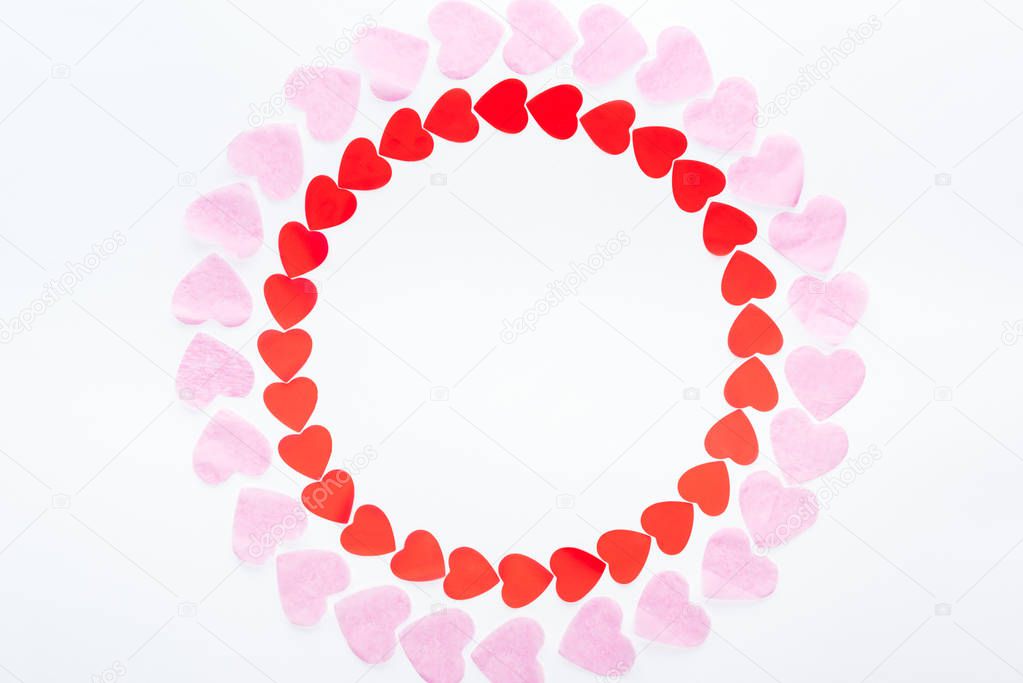 top view of round frame made with red and pink paper hearts isolated on white, st valentines day concept