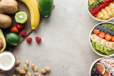 top view of colorful smoothie bowls with ingredients on grey background clipart