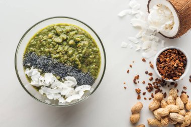 Beyaz arka plan üzerinde taze yeşil smoothie kase malzemelerle üstten görünüm