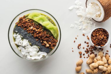 Beyaz arka plan üzerinde sağlıklı yeşil smoothie kase malzemelerle üstten görünüm
