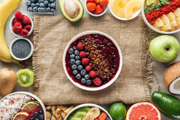 вид сверху на чаши и раму из свежих органических ингредиентов на мешковине
