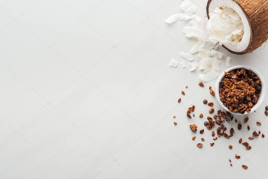 top view of granola and coconut with flakes on white background with copy space