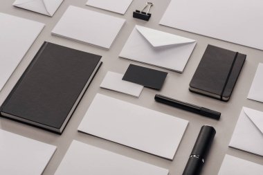 flat lay with white empty papers and black office supplies on grey background clipart