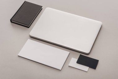 siyah ve beyaz boş kartları ve gri arka plan üstünde laptop ile düz lay