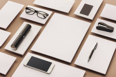 Kağıt, dava, Gözlük, smartphone, kalem ve zımba bej renkli arka plan üzerinde boş çarşafları