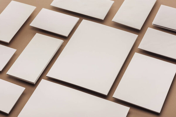 White cards and sheets of paper on beige background