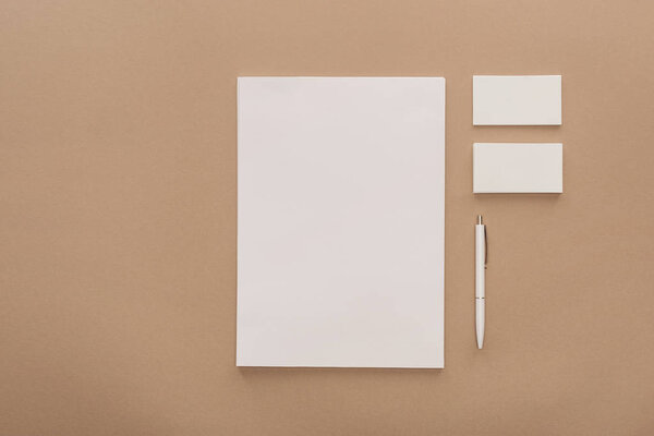 Вид сверху на пустой лист бумаги, открытки и ручку
 