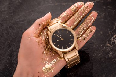 cropped view of golden wristwatch in hand of woman  clipart