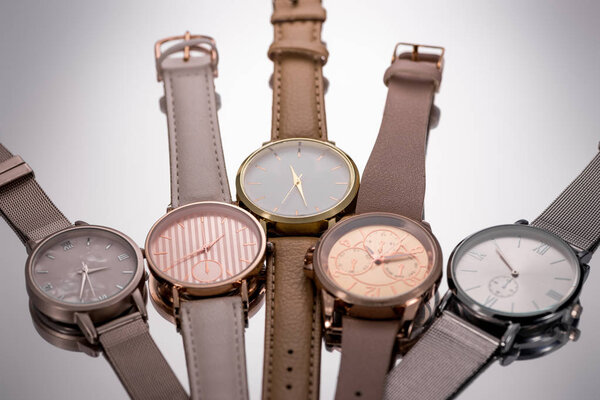 selective focus of luxury wristwatches lying on grey background