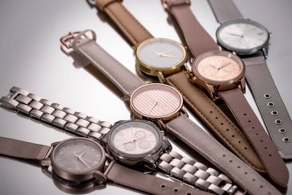 selective focus of elegant wristwatches lying on grey background