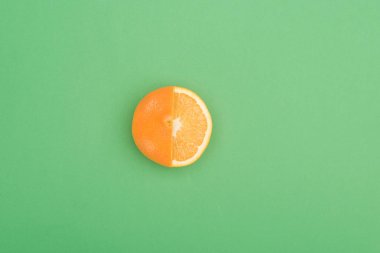 top view of fresh ripe juicy partially cut orange on green background clipart