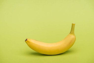 top view of fresh ripe banana on light green background clipart