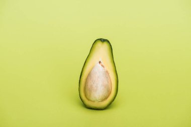 yeşil arka plan üzerinde olgunlaşmış taze lezzetli avokado yarısını