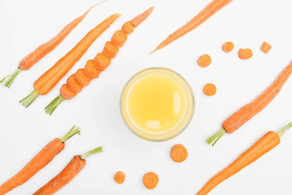 top view of bowl of carrot fresh juice, carrot slices, whole and cut carrots isoltated on white