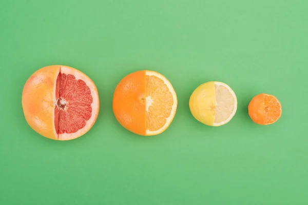 绿色背景上新鲜部分切割的葡萄柚 柠檬和橘子的顶视图 — 图库照片