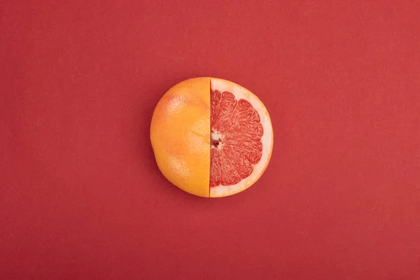 在红色背景上的新鲜成熟部分切割的葡萄柚的顶视图 — 图库照片
