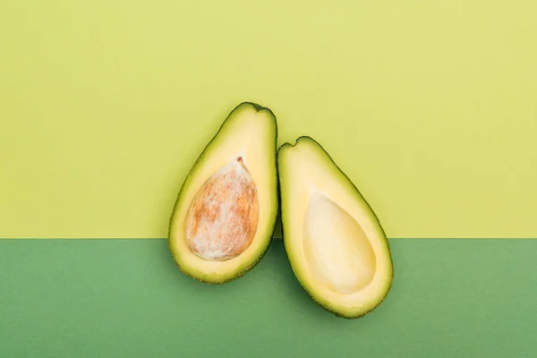 Bovenaanzicht Van Verse Rijpe Avocado Helften Bicolor Achtergrond — Stockfoto